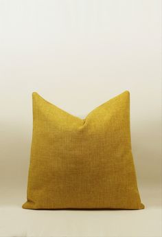 a yellow pillow sitting on top of a white table