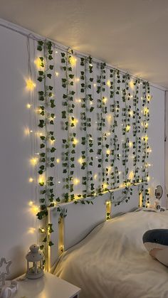 a bed with lights on the headboard and plants growing up the wall behind it