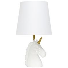 a white table lamp with a gold unicorn head on it's base and a white shade