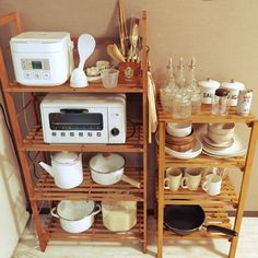 a kitchen shelf filled with pots and pans next to a microwave on top of a wooden rack