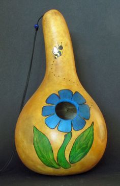 a pear shaped vase with blue flowers painted on it