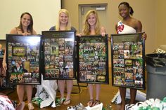 four women holding up framed pictures in front of them