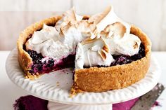 a blueberry pie on a white cake plate