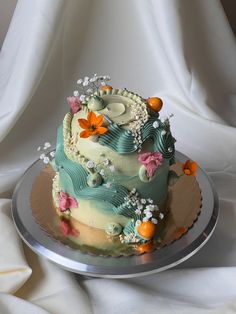 there is a cake with flowers on the top and bottom, sitting on a silver platter