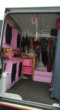 the back end of a van filled with lots of pink boxes and other things in it