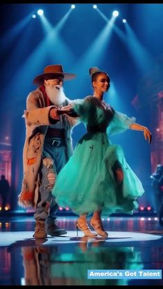 a man and woman dancing on stage with lights behind them