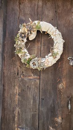 a wreath on the side of a wooden door that is covered in moss and lichen