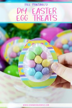 a hand holding an easter egg treat in front of some colorful candies and eggs