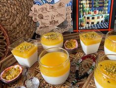 there are many desserts on the table with orange juice and nuts in bowls next to each other