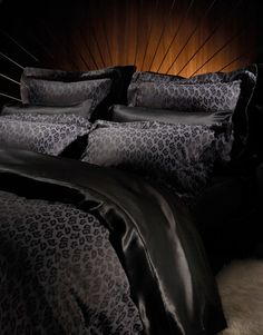 a bed with black sheets and leopard print on it