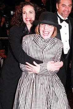 two women and a man in tuxedos are hugging each other at an event