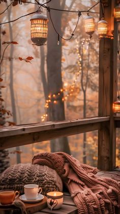 an outdoor deck with lights strung from the ceiling and blankets on it, next to a cup of coffee