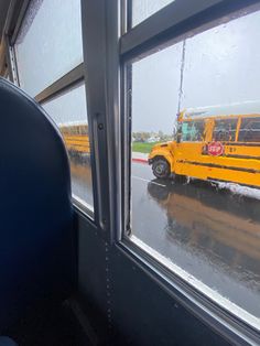 a school bus driving down the road in the rain with it's doors open