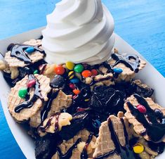 an ice cream sundae with chocolate, m & m candy bars and marshmallows