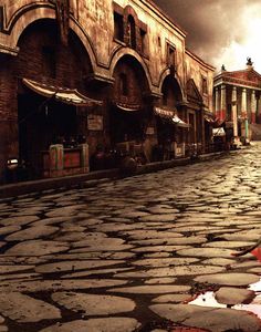 an empty street with cobblestones and buildings in the background