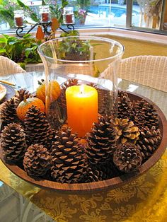 a table topped with pine cones and a candle