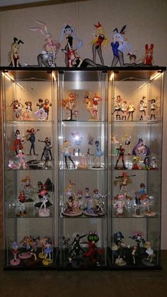 a display case filled with lots of cartoon figurines on top of glass shelves