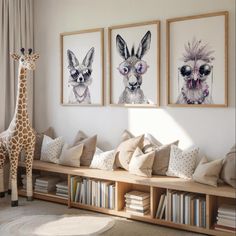 a giraffe standing next to two pictures on the wall in a living room