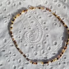 a beaded necklace on a white tablecloth