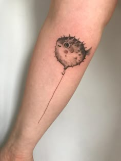 a small porcupine tattoo on the arm