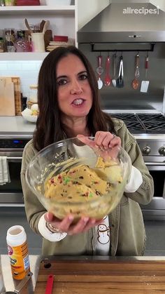 a woman holding a bowl with food in it