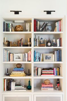 a white bookcase filled with lots of books