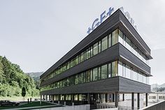 an office building with glass windows on the top floor