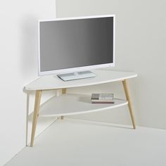 a computer monitor sitting on top of a white table next to a book shelf with books