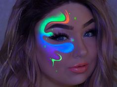 a woman's face painted with neon colors