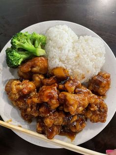 a white plate topped with chicken and broccoli next to rice