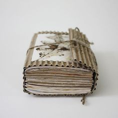 an old book is wrapped in twine and tied with rope on a white surface