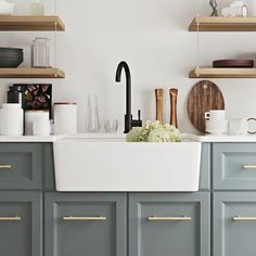 a kitchen with gray cabinets and white counter tops, black faucet in the center