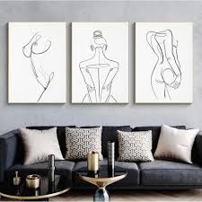 three black and white paintings on the wall above a couch