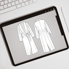 a tablet with a drawing of a robe on it next to a keyboard and mouse