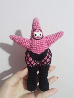 a crocheted pink and black starfish with eyes on it's body