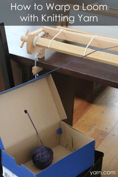 an open box sitting on top of a wooden table next to a yarn loom