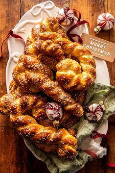 a white plate topped with pastry covered pretzels next to a christmas ornament