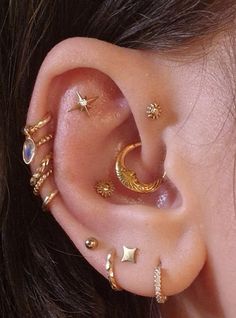 a close up of a person's ear with different types of piercings on it