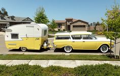 an old yellow and white bus parked next to a camper on the side of the road