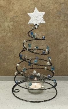 a small christmas tree made out of wire and glass beads with a star on top