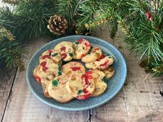 christmas cookies on a blue plate next to pine branches