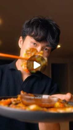 a man holding a plate with food on it and an ad in front of him