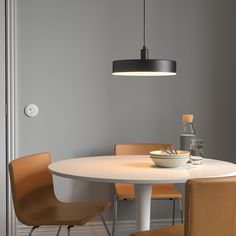 a white table with four chairs around it and a bowl of food on the table