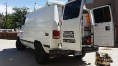 a white van parked in front of a house with its doors open and the back door opened