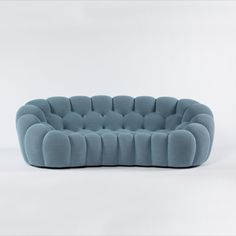 a blue couch sitting on top of a white floor