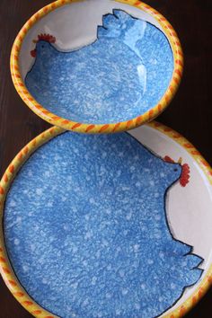 two blue and yellow plates with rooster designs on them