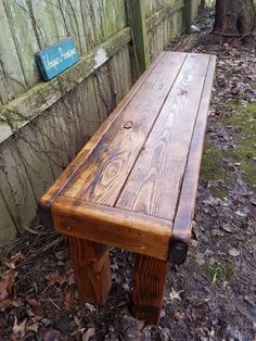 a wooden bench sitting next to a fence