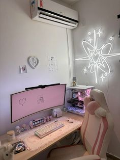 a desk with a computer monitor and keyboard on it in front of a neon sign