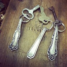 three antique keys are sitting on a wooden table