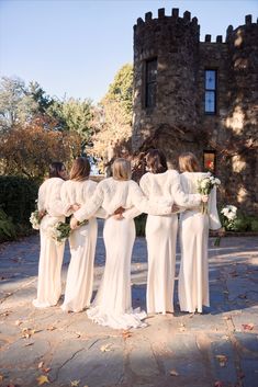 a group of women in white dresses standing next to each other